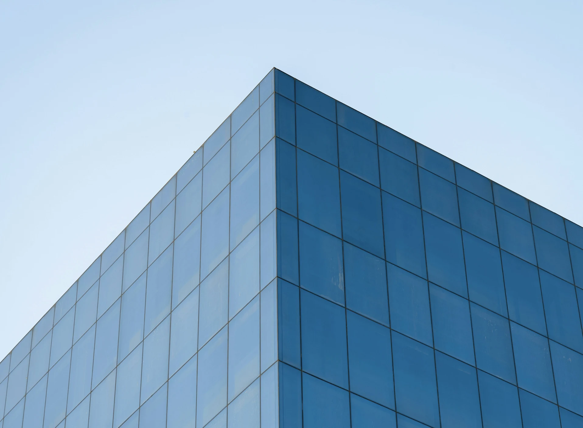 Blue glass building corner against a clear sky — verified lawyers and law firms on Global Law Lists, the international legal network