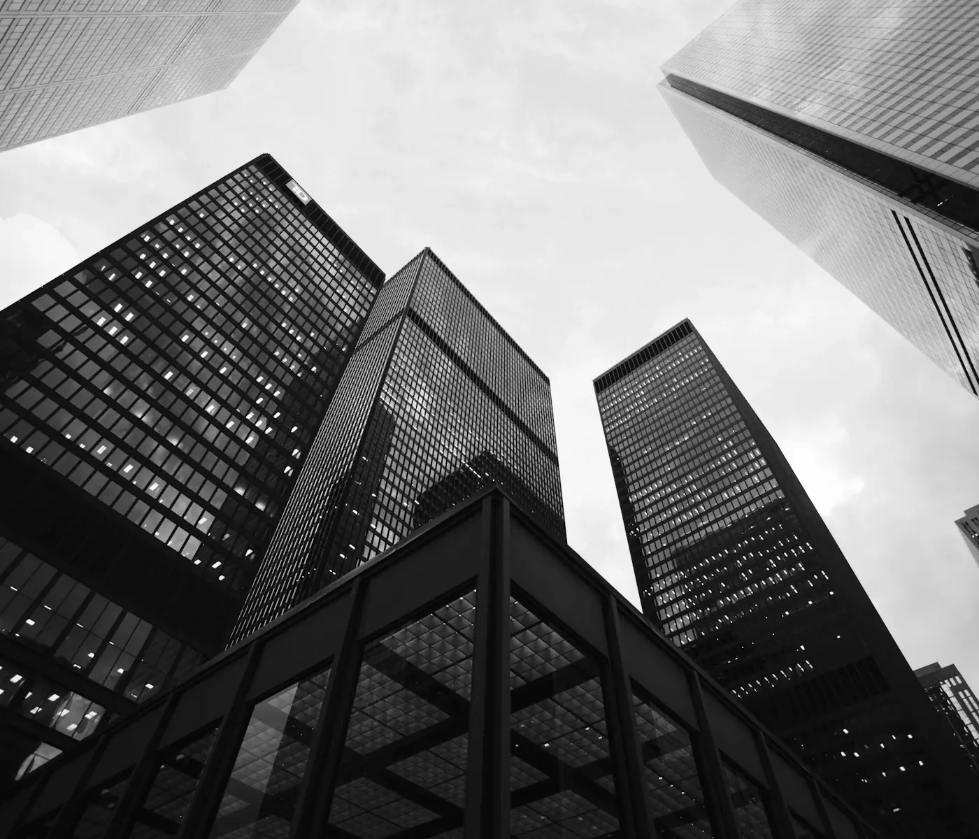 Glass office towers of a financial district seen from street level, looking up