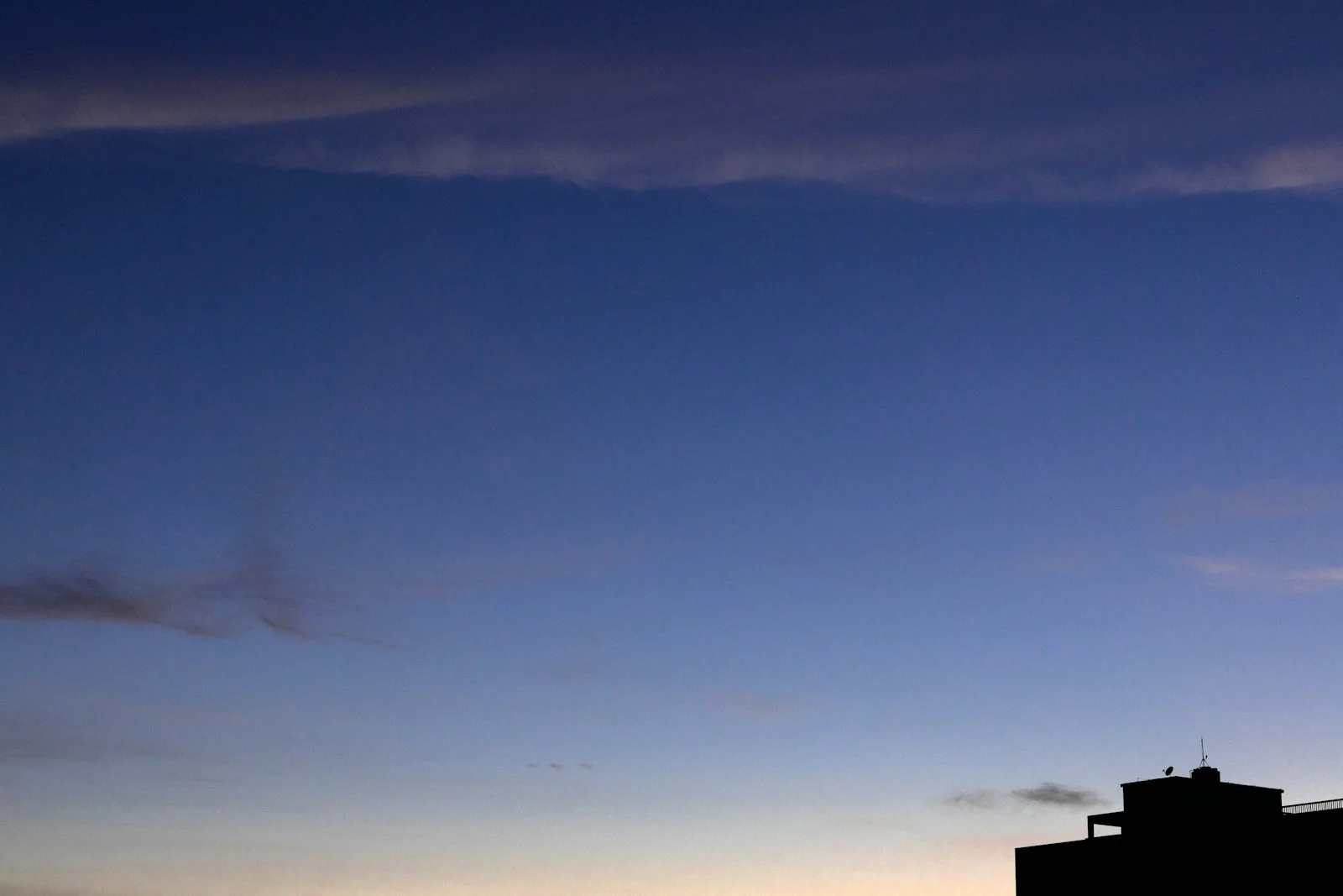 A dark building silhouette against a twilight sky