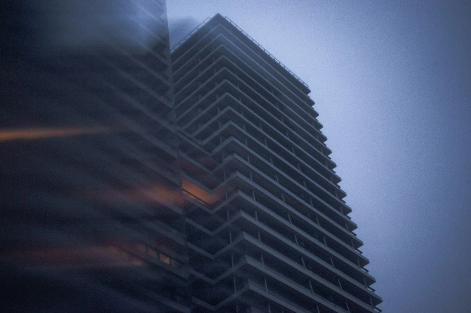 A tall modern skyscraper against a cloudy sky