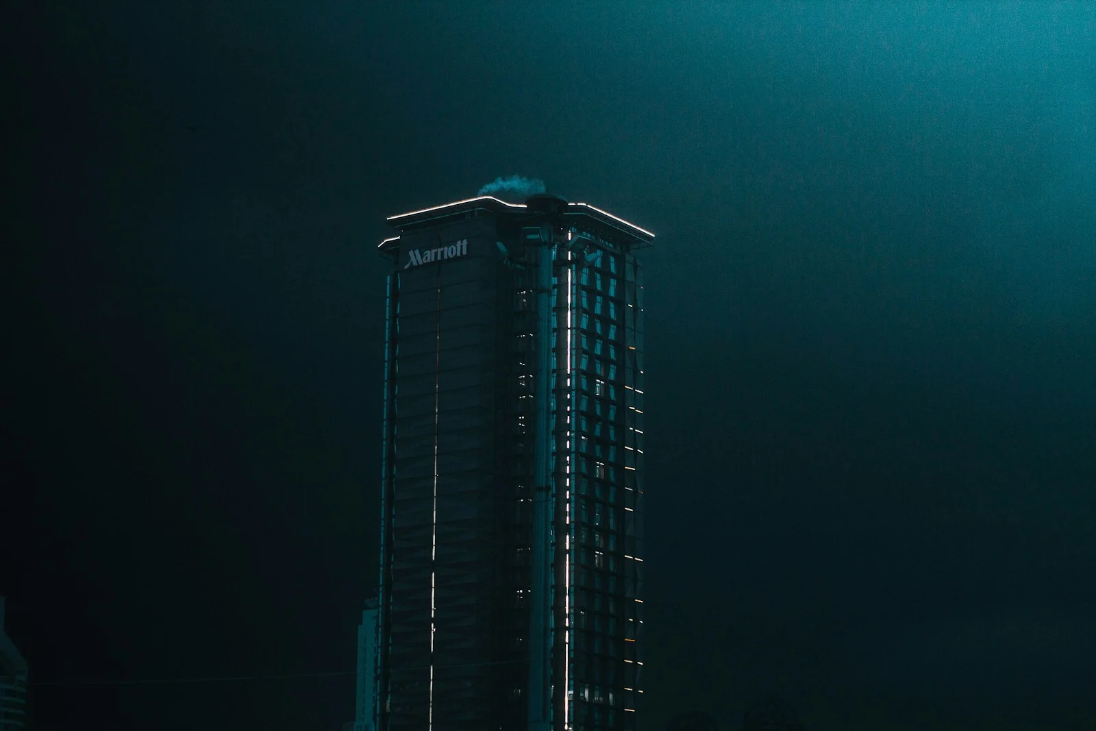 The facade of a dark glass tower, seen from below